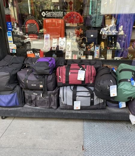 Cheap luggage on a Chinatown sidewalk.
